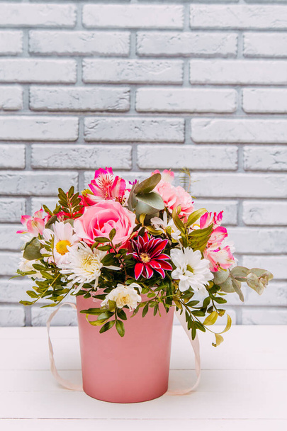 Delicate bouquet of different flowers in pink packaging. Square photo close-up - 写真・画像