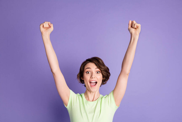 Portrait of attractive cheerful lucky brown-haired girl celebrating rising hands up isolated over violet color background - Foto, Bild