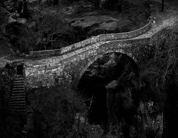Die Misarela-Brücke, die im Mittelalter erbaut wurde, wurde einer lokalen Legende zufolge vom Teufel selbst erbaut. Geres National Park, Portugal. - Foto, Bild