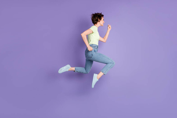 Full length body size profile side view of lovely cheerful motivated girl jumping running fast isolated over violet color background - Photo, Image