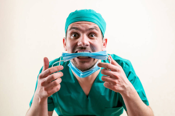 Funny doctor with a medical mask in his hands. High quality photo - Fotó, kép