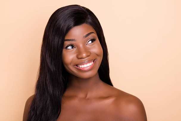 Photo of dreamy charming dark skin naked lady smiling looking empty space isolated beige color background - 写真・画像