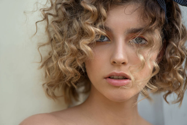 Portrait of Beautiful Fashion Model with Wavy Curly Hair and Colored Make-up. Make up and Hair. Haircare concept. Close-up, Selective focus. - Photo, Image