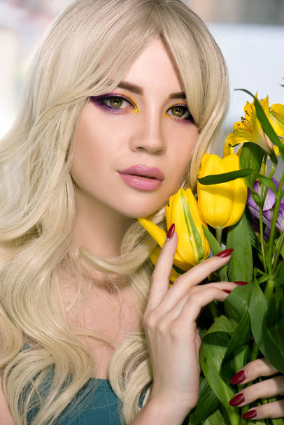 Fashion model with creative professional make-up with purple and yellow color  and flower in hand. SPA and wellness, bodycare and skincare concept. - Fotoğraf, Görsel