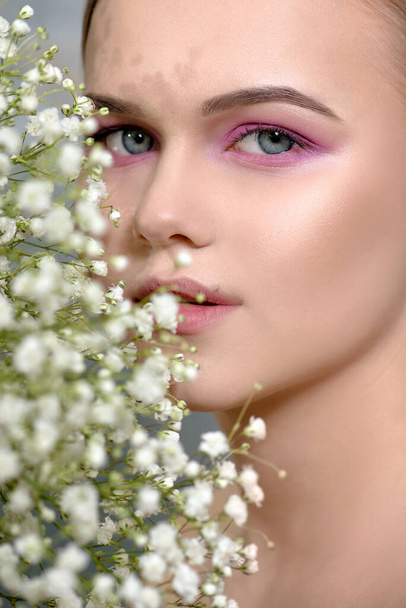 Beautiful young woman with perfect skin posing with flowers.  SPA, wellness, bodycare and skincare. - Foto, immagini