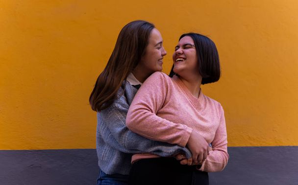 mooi lesbisch paar houden van elkaar in de straat, het nemen van foto 's met de telefoon en lachen en wandelen met de trots vlag LGBT concept - Foto, afbeelding