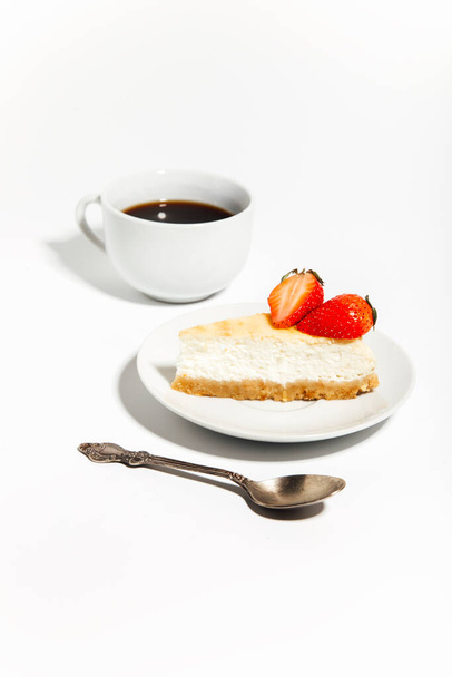 Classic vanilla cheesecake with strawberries and cup of coffee on white background  - Foto, immagini