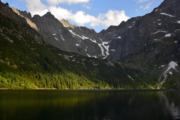 Lake Morskie oko, also called Eye of the Sea, surrounded by forest and mountains. High Tatras, Poland. Golden hour. - Photo, image