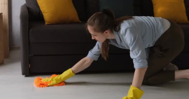 Schoonmaakster wast de vloer met een doek. Huisvrouw maakt de kamer schoon. Jonge vrouw maakt de vloer schoon. Langzame beweging. Daglicht.  - Video