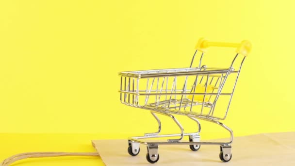 leeg Winkelwagen op een gele achtergrond, close-up. Black Friday Shopping en Korting Concept - Video