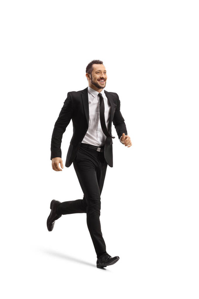 Full length shot of a happy businessman running and smiling isolated on white background - Valokuva, kuva