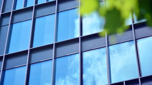 Fachada de cristal de los edificios con cielo azul. Edificio moderno en el centro de negocios. Antecedentes de edificios modernos de vidrio.  - Foto, imagen