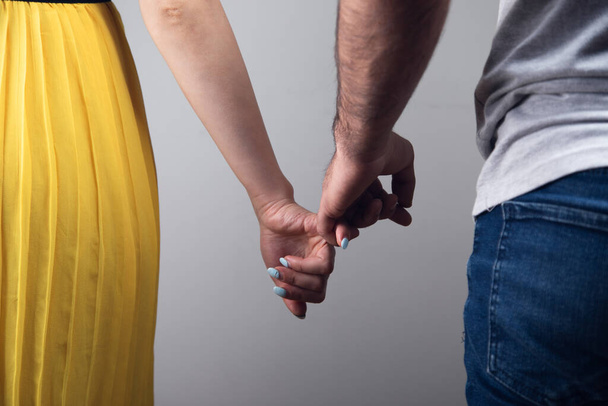 άντρας και γυναίκα κρατούν τα δαχτυλάκια τους. - Φωτογραφία, εικόνα