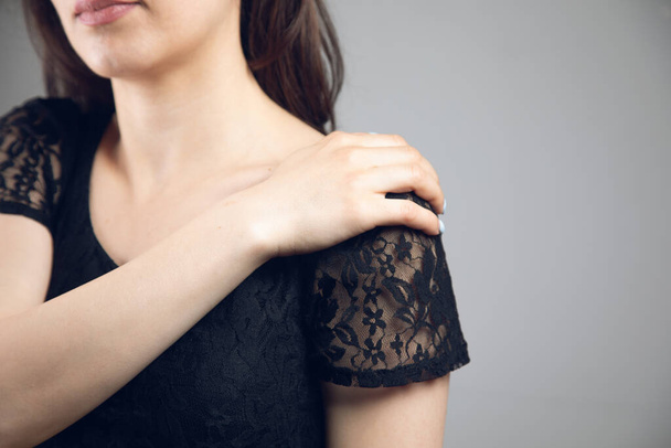 uma jovem mulher tem uma dor no ombro - Foto, Imagem