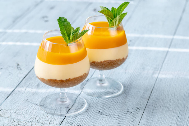 Mangový tvarohový dort zdobený mátou podávanou ve sklenicích - Fotografie, Obrázek
