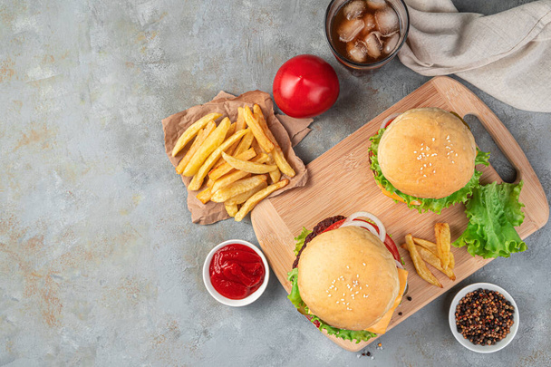 Hamburger, patatine fritte e cola su fondo grigio. Fast food. Vista dall'alto, copia spazio. - Foto, immagini