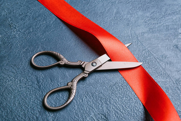 Червона стрічка і ножиці на темному тлі, крупним планом
 - Фото, зображення