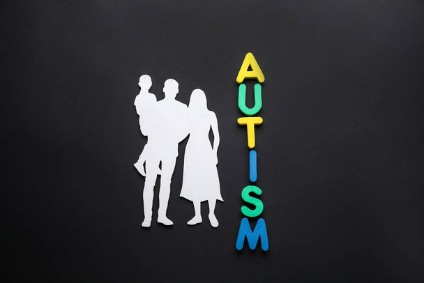Family figure and Word AUTISM on dark background - Фото, изображение