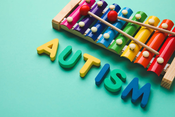 Word AUTISM and xylophone on color background - Foto, Imagem