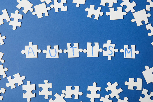 Word AUTISM made of puzzles on color background - 写真・画像