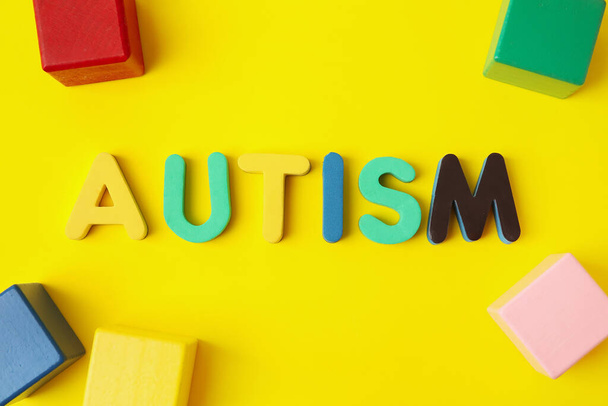 Word AUTISM and cubes on color background - Foto, Imagem