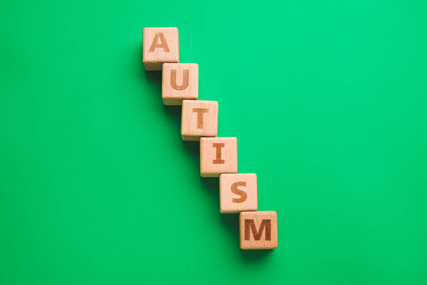 Word AUTISM made of cubes on color background - Foto, imagen