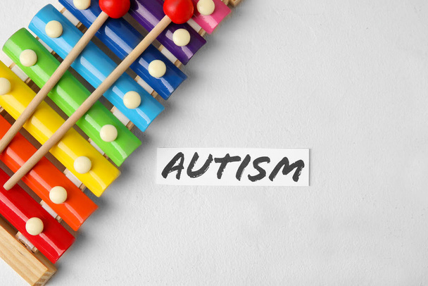 Word AUTISM and xylophone on light background - Photo, Image