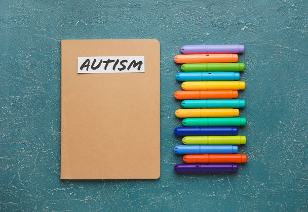Notebook with word AUTISM and markers on grunge background - Photo, Image