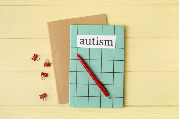 Notebooks with word AUTISM and pen on color wooden background - Photo, Image