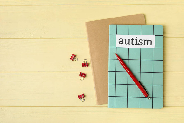 ノートブックと単語自閉症とペンの色木製の背景 - 写真・画像