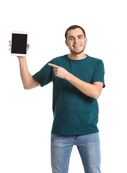 Young man pointing at tablet computer on white background - Fotó, kép