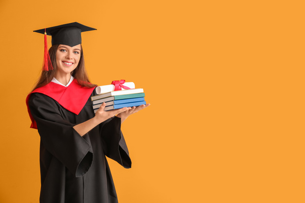 Female graduating student with diploma and books on color background - Photo, Image