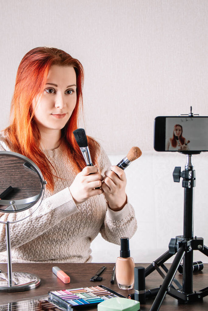 Beauty blogger influencer prowadzi strumień online. Młoda kobieta pokazuje, jak zrobić makijaż i używać kosmetyków. - Zdjęcie, obraz
