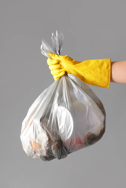 Woman holding bag with garbage on grey background, closeup - Фото, зображення