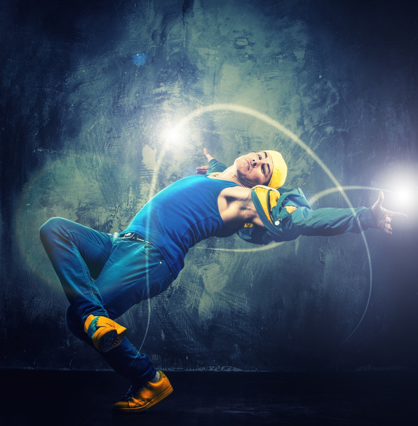 καλαίσθητο άνθρωπος χορευτής δείχνει breakdance που τόσο κινήσεις με μαγικά δοκάρια γύρω του  - Φωτογραφία, εικόνα
