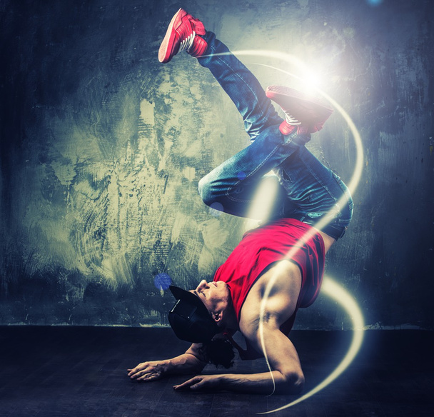 elegáns férfi táncos mutatja a mágikus gerendák körülötte break-táncos mozog  - Fotó, kép