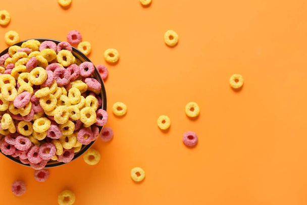 Ciotola con gustosi anelli di cereali su sfondo di colore - Foto, immagini