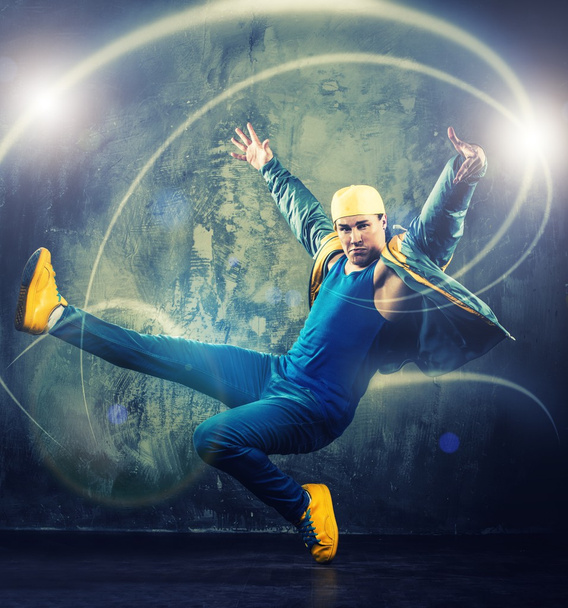 Danseur homme élégant montrant des mouvements de break-dance avec des poutres magiques autour de lui
  - Photo, image