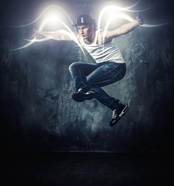 彼の周りの魔法ビームと休憩を示すスタイリッシュな男性ダンサーの動き  - 写真・画像