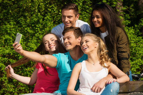 Multi ethnic group of sporty teenage friends in a park taking selfie - Photo, Image