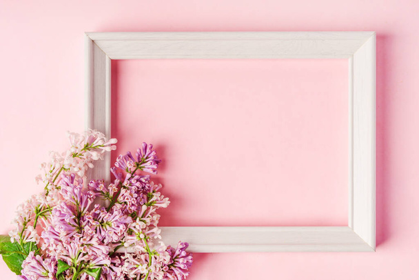 Floral composition with a place for text in the form of a frame of lilac on pink background. - Foto, Imagen