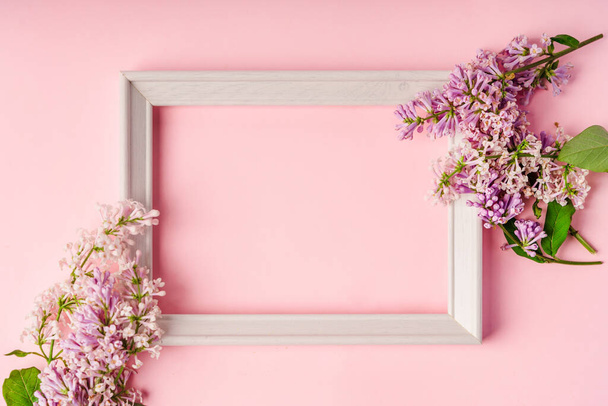 Virágkompozíció egy hely a szöveg formájában egy keret orgona rózsaszín háttér. - Fotó, kép