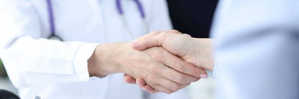 Doctor and the patient shake hands closeup - 写真・画像