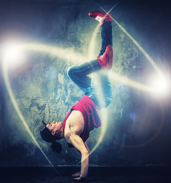 elegáns férfi táncos mutatja a mágikus gerendák körülötte break-táncos mozog  - Fotó, kép