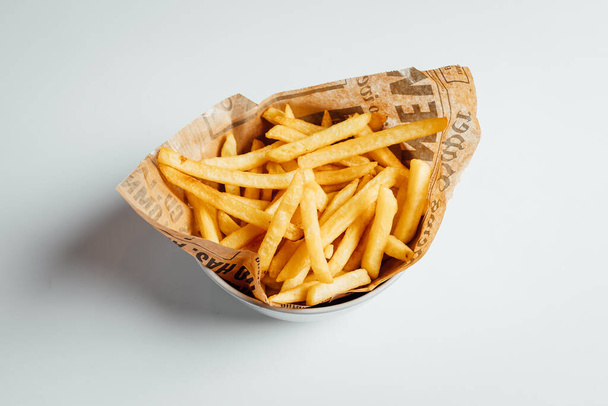 View on freshly fried fries in bowl on bright backgroud - Fotó, kép