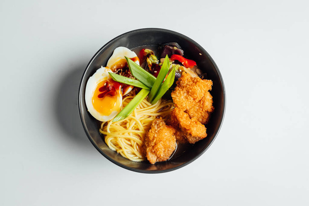 Ramen soup with fried chicken and egg on bright background - Photo, Image