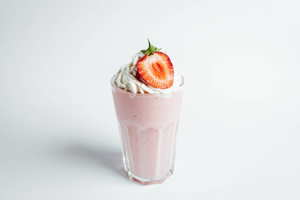 Стаканы свежего клубничного молочного коктейля, летний коктейль с ломтиком клубники на ярком фоне - Фото, изображение