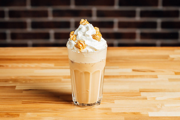 Caffè freddo caffelatte con crema e popcorn caramello su tavolo luminoso, caffè sho - Foto, immagini