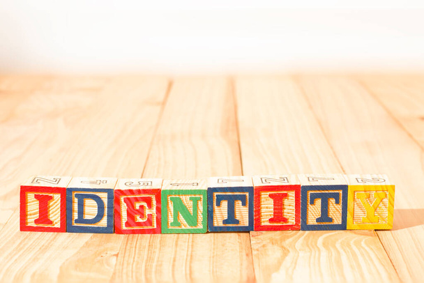 Spectacular colorful wooden cubes with the word identity on a wooden background. - Photo, Image