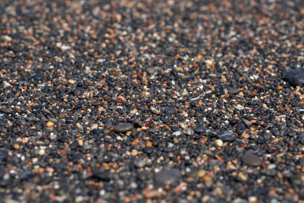 Sfondo astratto con nero e arancio rotondo mare ciottoli texture sulla riva vicino alla luce del tramonto offuscata, primo piano, spazio copia naturale . - Foto, immagini
